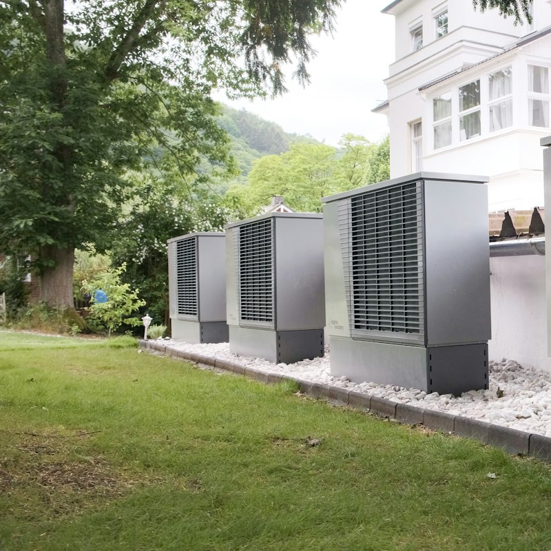 Row of outdoor heat pump units on a lawn