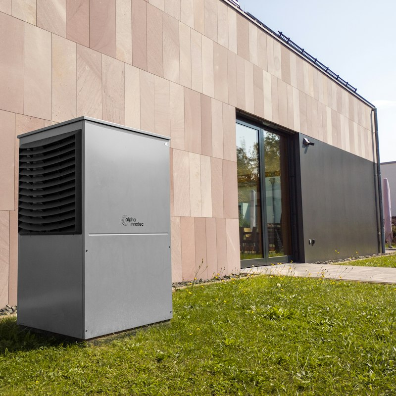 Newly installed outdoor heat pump next to a modern building
