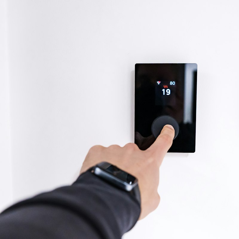 Homeowner adjusting a digital thermostat